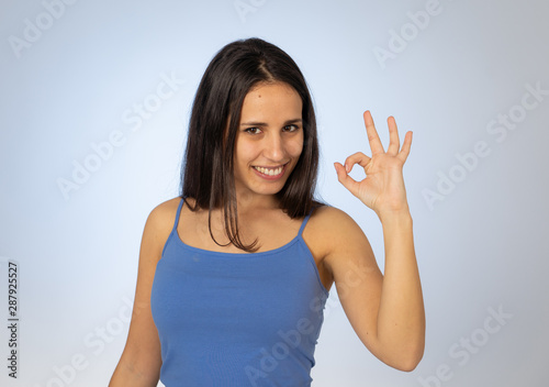 Portrait of pretty teenager girl making ok gestures with happy and satisfied face