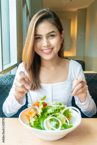 Beautiful healthy woman is holding vegetables salad