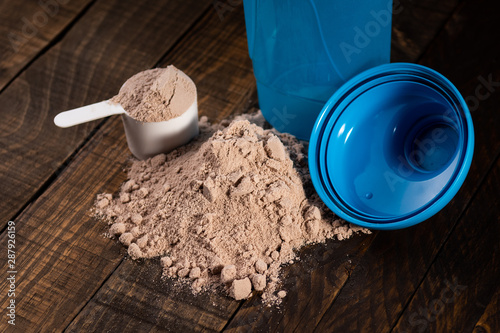 Obraz na plátně Measuring scoop of whey protein on wooden table to prepare a milkshake