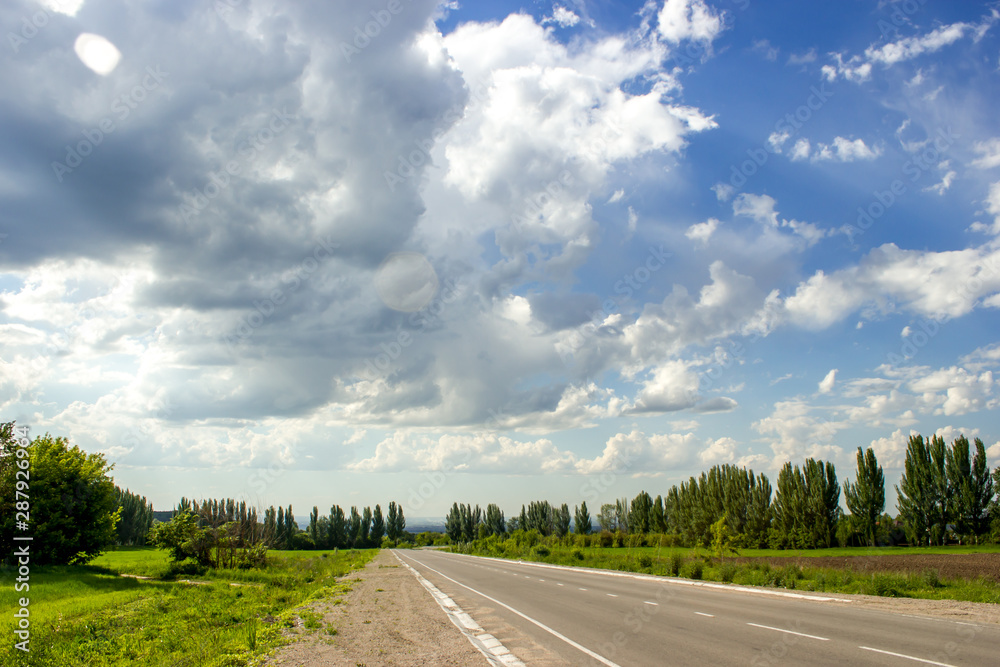 Beautiful summer landscape with clouds in blue sky in the countryside with the view from Talgar Almaty road, Kazakhstan. Road trip travel background.