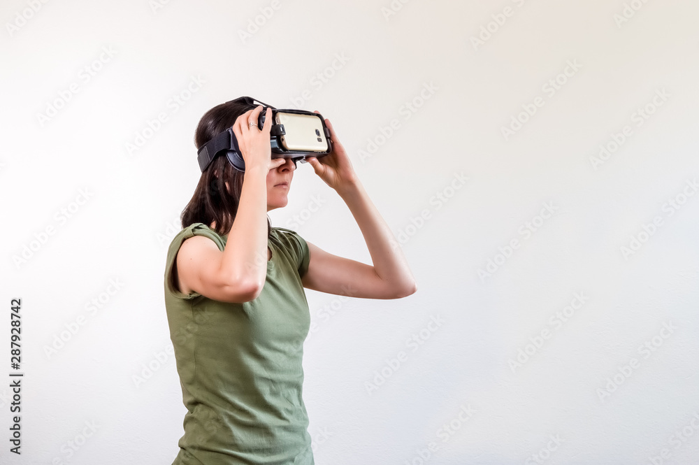 Brunette woman exploring modern technology virtual reality with head mounted display on white background Brunette woman exploring modern technology virtual reality with head mounted display on white background