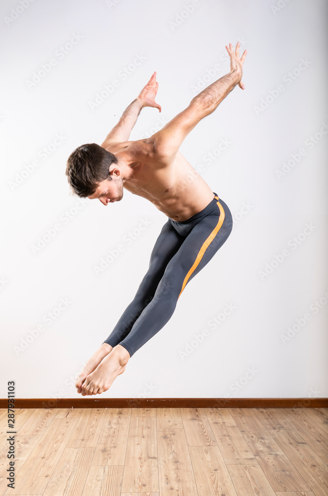 Naklejka premium Beautiful male ballett dancer performing indoor
