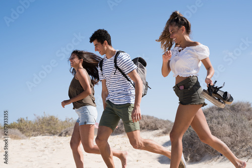 Two girls and a boy running and laughing