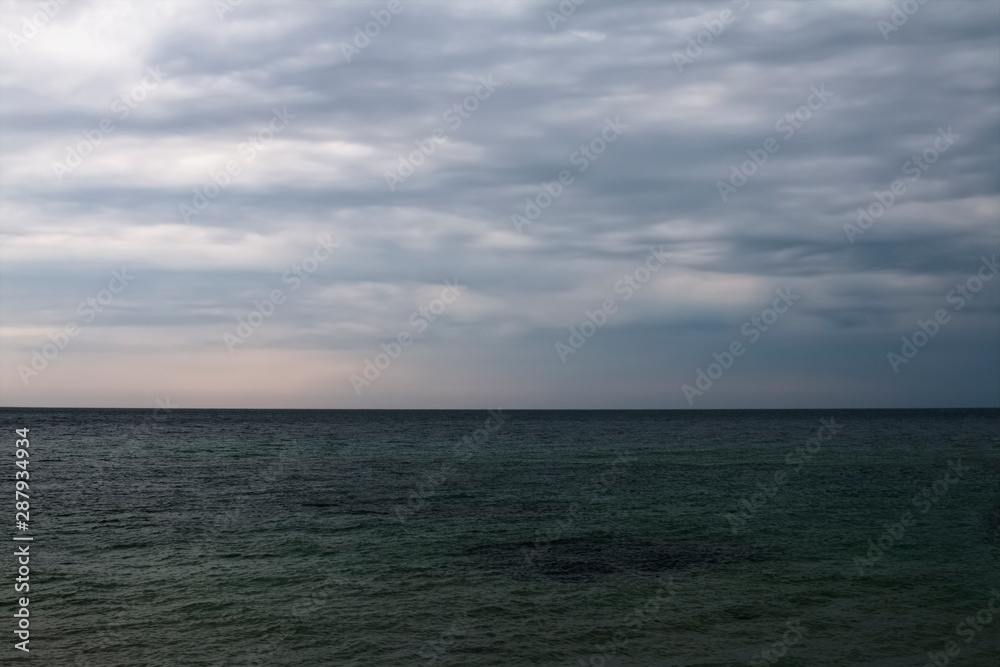 Marine background, skyline, cloudy sky over the sea.