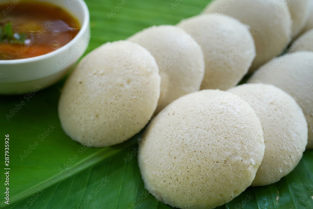 Idlis /Steamed rice cakes - South Indian breakfast served in banana leaf, selective focus Idlis /Steamed rice cakes - South Indian breakfast served in banana leaf, selective focus