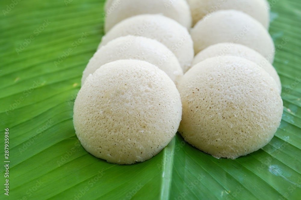 Idlis /Steamed rice cakes - South Indian breakfast served in banana leaf, selective focus Idlis /Steamed rice cakes - South Indian breakfast served in banana leaf, selective focus