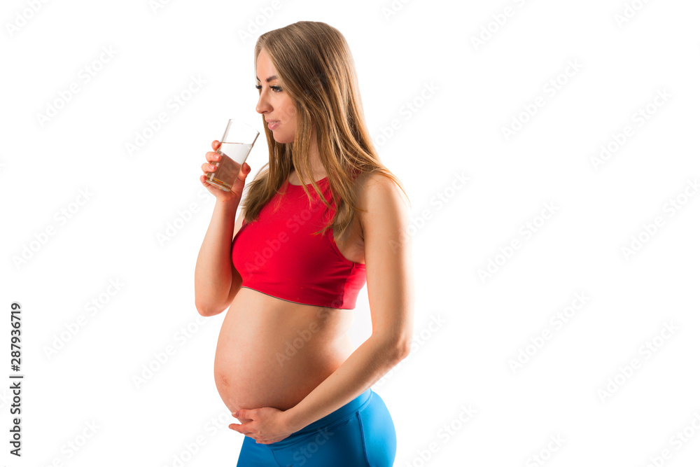beautiful young pregnant woman in sportswear with a glass of water beautiful young pregnant woman in sportswear with a glass of water
