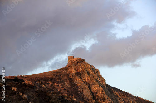 Golden effect caused by the reflection of the sun on the slope of the castle of Algoso