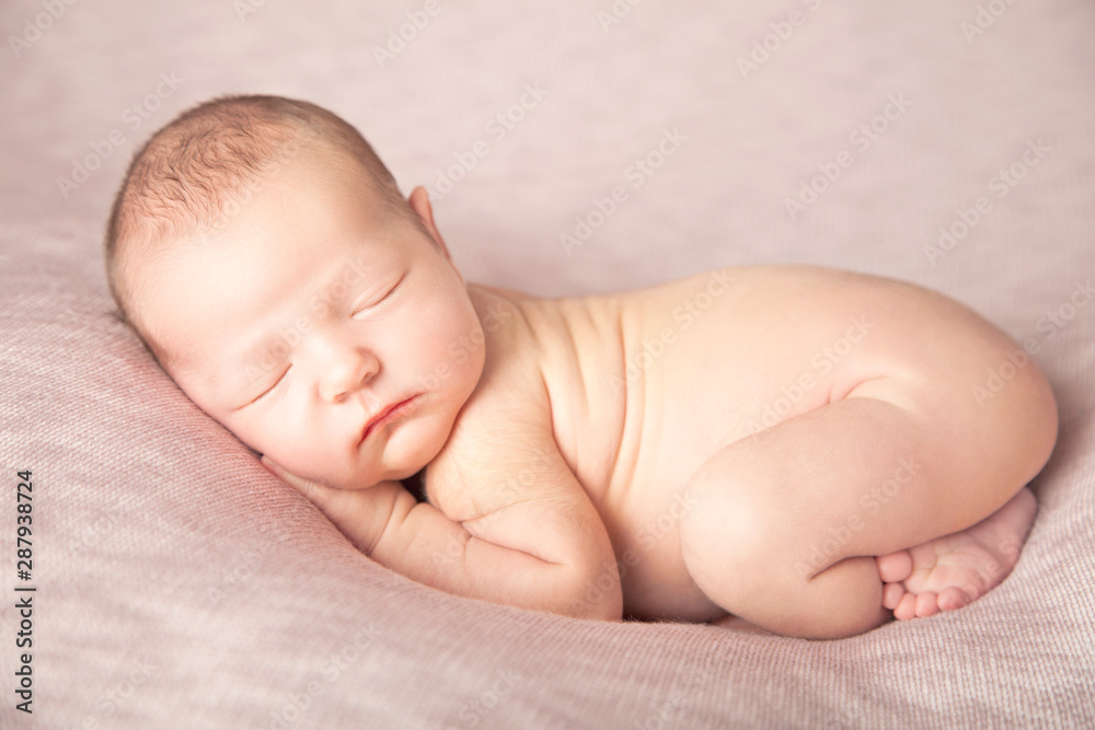 Newborn baby girl sleeping like a baby on a pink beanbag Newborn baby girl sleeping like a baby on a pink beanbag