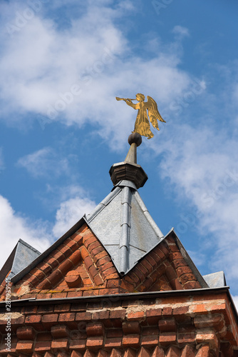 Golden trumpet angel on brick wall tower,  Chernigovsky skete of the Holy Trinity Sergius Lavra  in Sergiev Posad, Russia photo