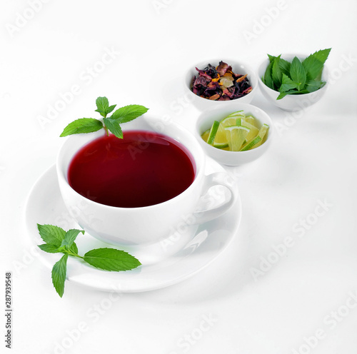 Cup of hot tea with lime and mint on white background