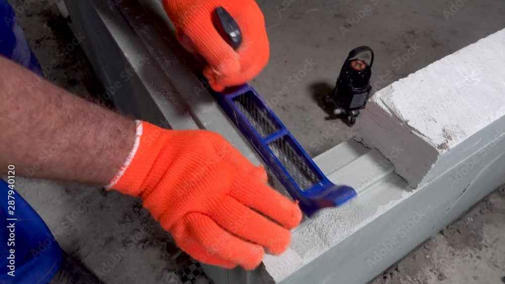 Builder grinds a plasterboard block with a planer, apartment or home repair Builder grinds a plasterboard block with a planer, apartment or home repair