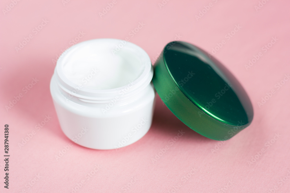 Open jar of face cream on a pink background. Open jar of face cream on a pink background.