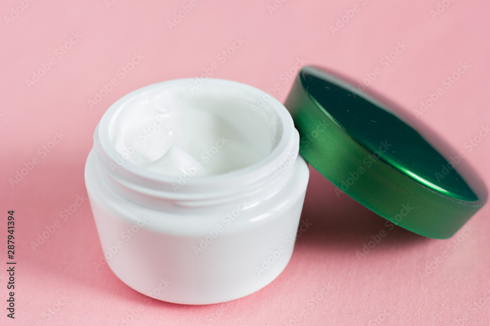Open jar of face cream on a pink background. Open jar of face cream on a pink background.