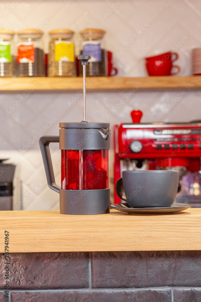 Glass black fruit tea in glass teapot on wooden kitchen background Glass black fruit tea in glass teapot on wooden kitchen background