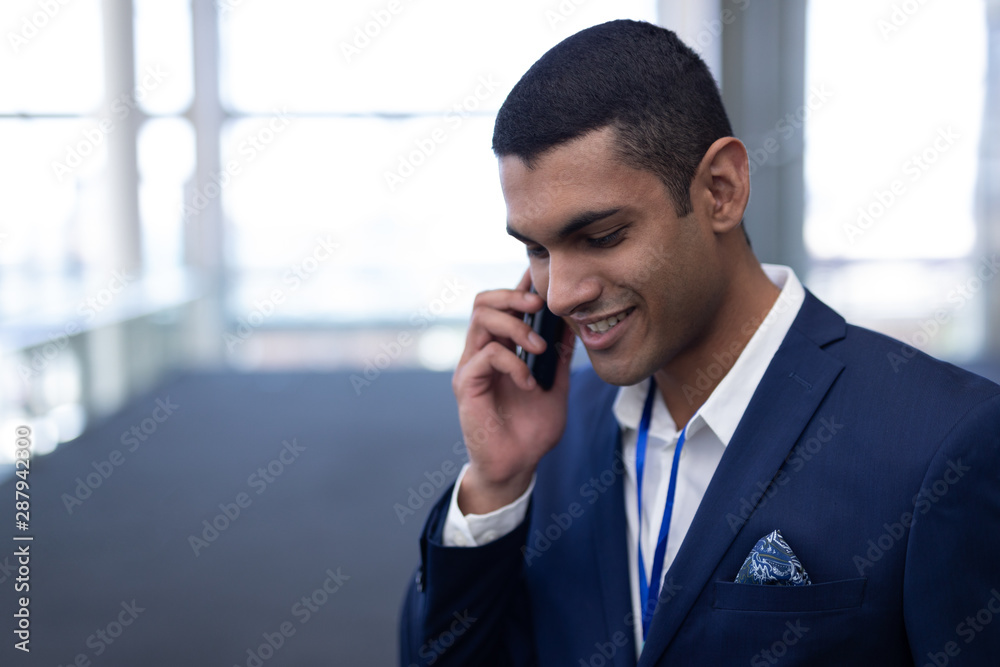 Businessman talking on mobile phone in office Businessman talking on mobile phone in office