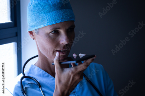 Female surgeon talking on mobile phone at hospital 