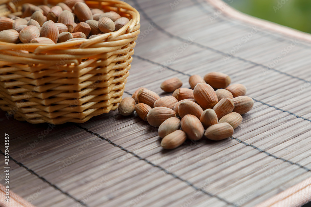 Hazelnut fruits. Healthy diet vegetarian food. Filbert natural healthy hazel in a basket strewn on a brown background. Crop Production, Nut Harvesting Season Hazelnut fruits. Healthy diet vegetarian food. Filbert natural healthy hazel in a basket strewn on a brown background. Crop Production, Nut Harvesting Season