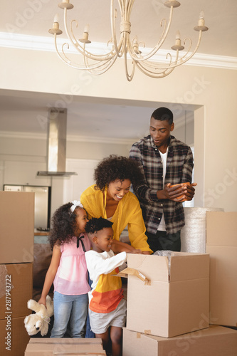 Foto Happy African American parents with their children packing their belongings in l