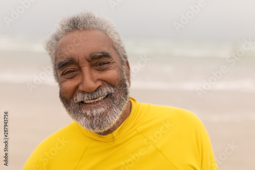 Happy senior man looking at camera on the beach