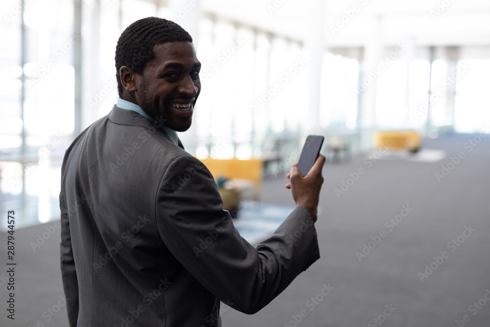 African-American businessman using mobile phone in office African-American businessman using mobile phone in office