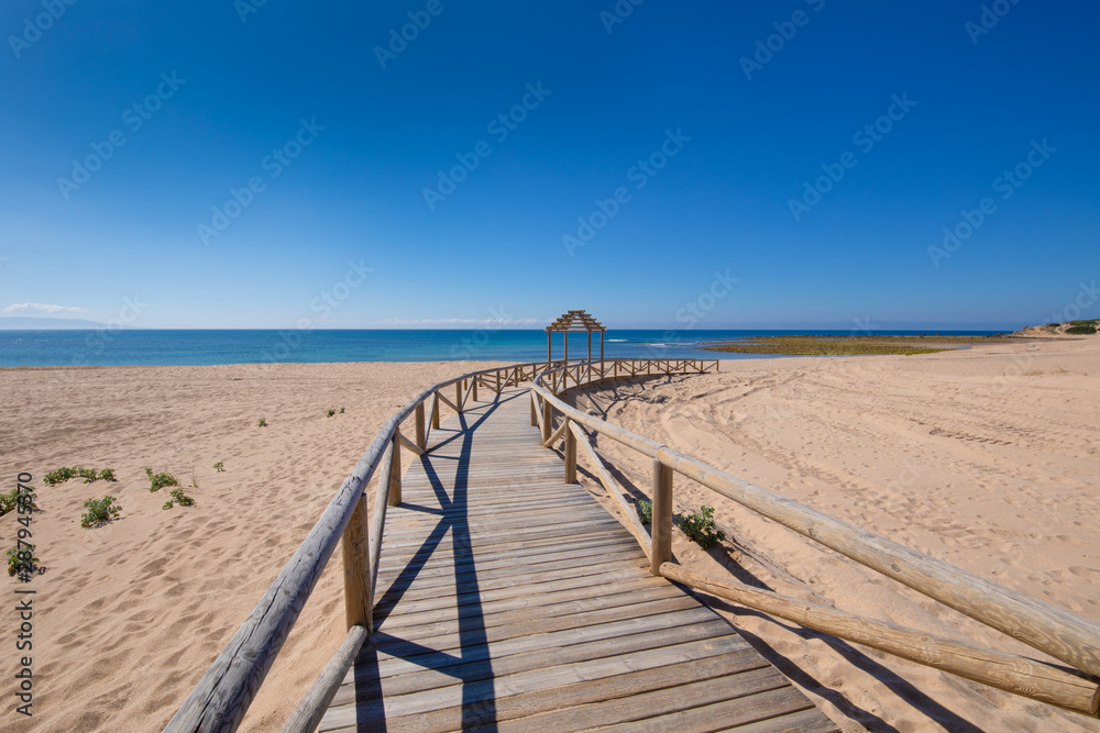 long curve wooden footpath structure of Beach Varadero and Marisucia, in Canos Meca village (Barbate, Cadiz, Andalusia, Spain)