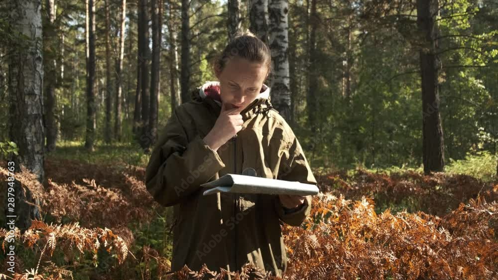 Woman lost in the forest, looking at old map, thinking, nature background, concept: search for yourself. Woman with map in forest. Woman lost in the forest, looking at old map, thinking, nature background, concept: search for yourself. Woman with map in forest.