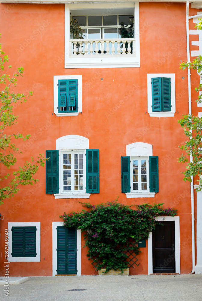  facade of mediterranean building with colorful shutter 