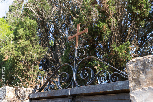 The upper part of the metal gate decorated with decorations and a cross in the catholic Christian Transfiguration Church located on Mount Tavor near Nazareth in Israel