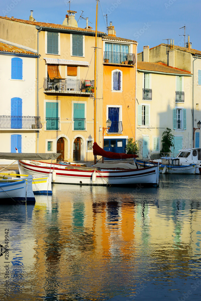  facade of mediterranean building with colorful shutter with river and boat