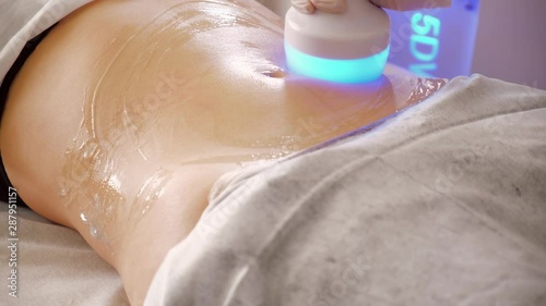 Hardware cosmetology. Body care. Spa treatment. Ultrasound cavitation body contouring treatment. Woman getting anti-cellulite and anti-fat therapy in beauty salon.
