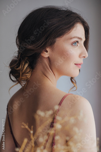 Portrait of beautiful tender blue-eyed young woman in silky nightgown. photo