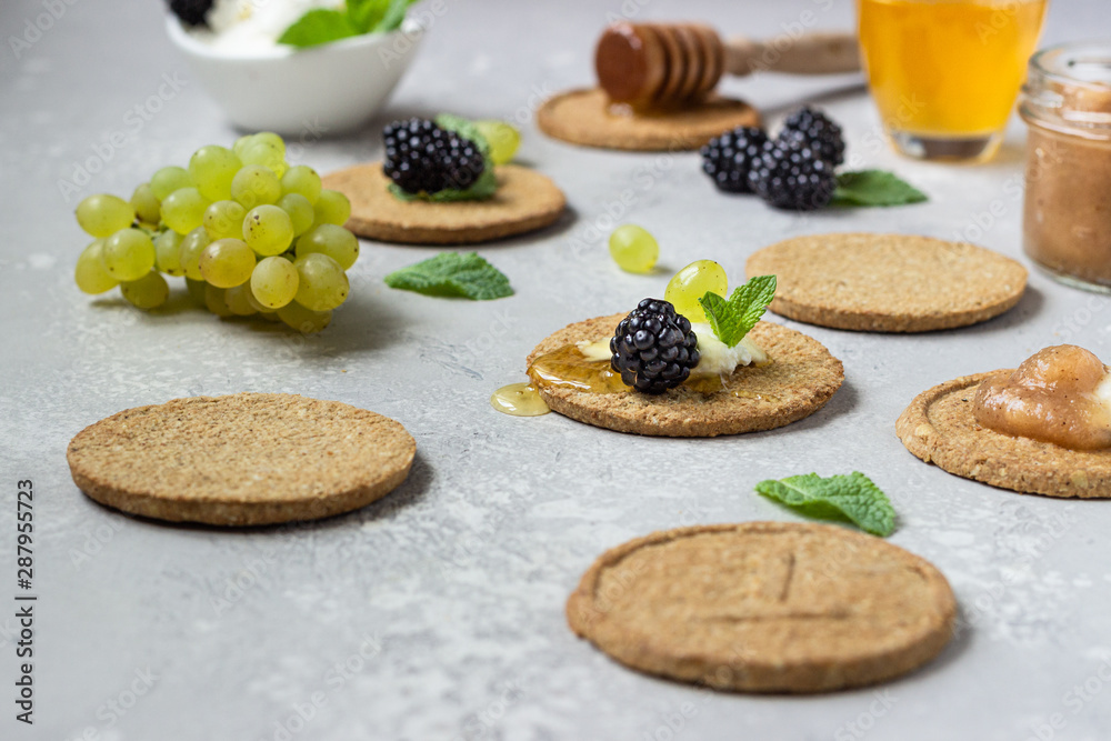Thin crispy wholegrain crackers with cream cheese, blackberry, grapes, mint and honey. 