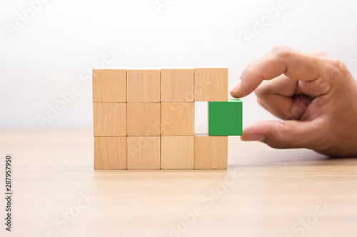 Hand Choosing wooden block,wood cubes Arrange stacking with out graphic for Business concept growth and success process.