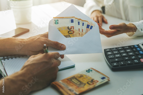 Canvastavla illegal employment tax evasion concept - hand giving envelope with cash money