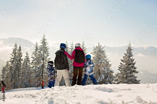 Beuatiful family with two kids, skiing on a sunny day in scenery austrian Alps © Tomsickova