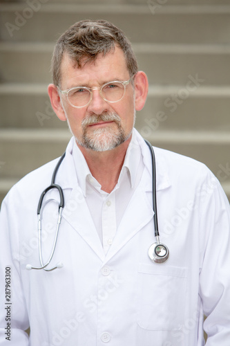 handsome doctor in his 50s standing outside