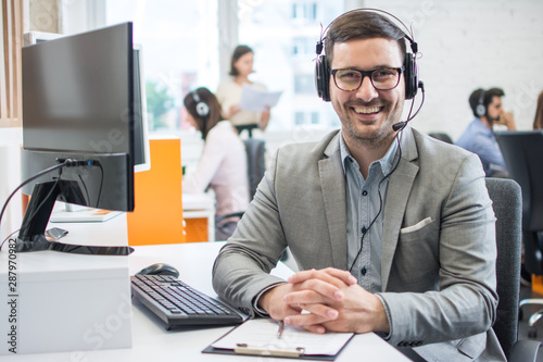 Customer service representative business man with headset in call center photo