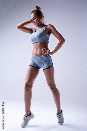 The beauty lady in exercise suit is acting,show texture of fit and firm body