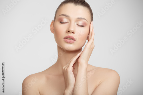woman with clean skin touches her cheeks with her hand. facial skin concept on