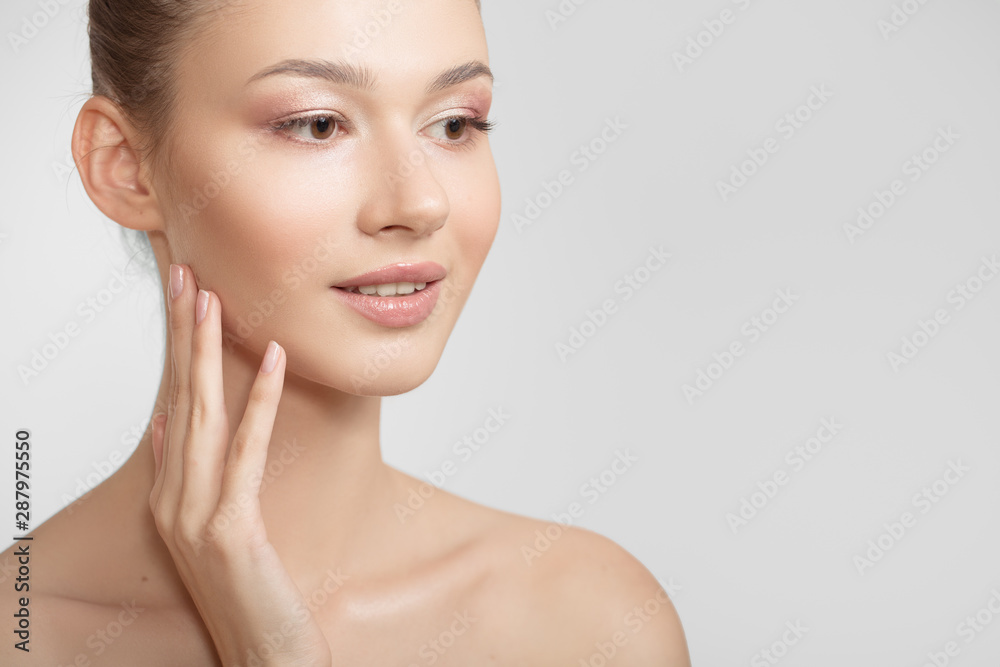 Portrait of a young woman. Bare shoulders. Hand touches face Portrait of a young woman. Bare shoulders. Hand touches face