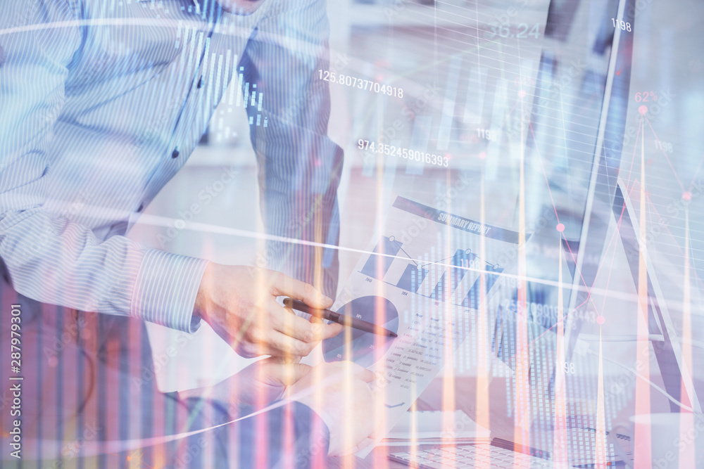 Double exposure of chart with businessman typing on computer in office on background. Concept of hard work. Double exposure of chart with businessman typing on computer in office on background. Concept of hard work.