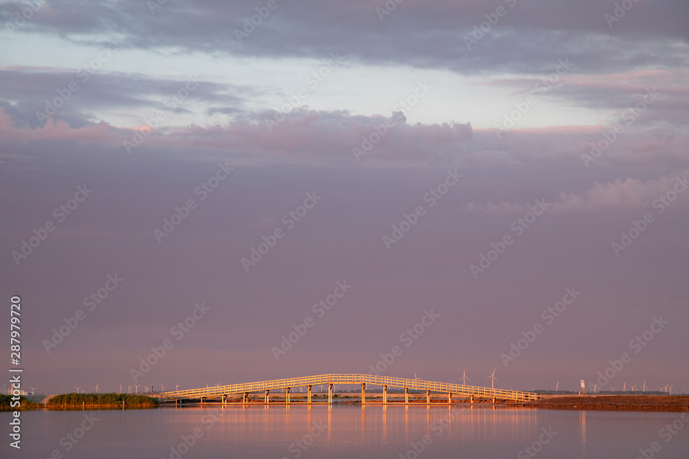 Bridge on the Markerwadden at sunset.The Marker Wadden,artificial archipelago in development located in the Markermeer. Bridge on the Markerwadden at sunset.The Marker Wadden,artificial archipelago in development located in the Markermeer.