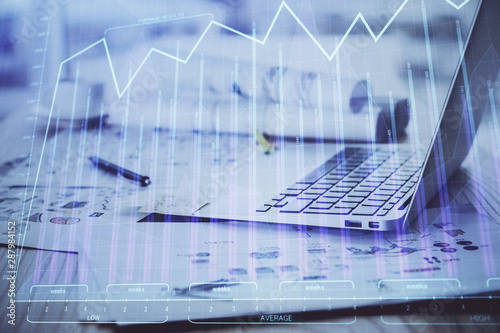 Stock market graph on background with desk and personal computer. Double exposure. Concept of financial analysis.