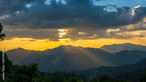 Time-lapse Sunray thought cloud from above show background dramatic motion from sunset , zoom in..