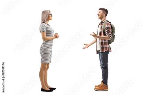 Young woman listening to a male student explaining and gesturing with hands