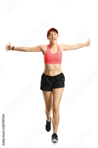 Young smiling woman in sportswear running and spreading arms