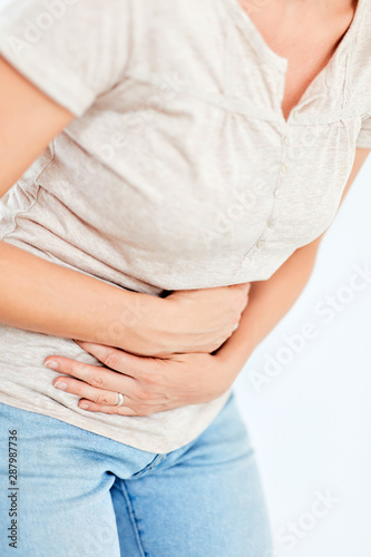 Woman with stomach/ hip issues / problems on the white background.
