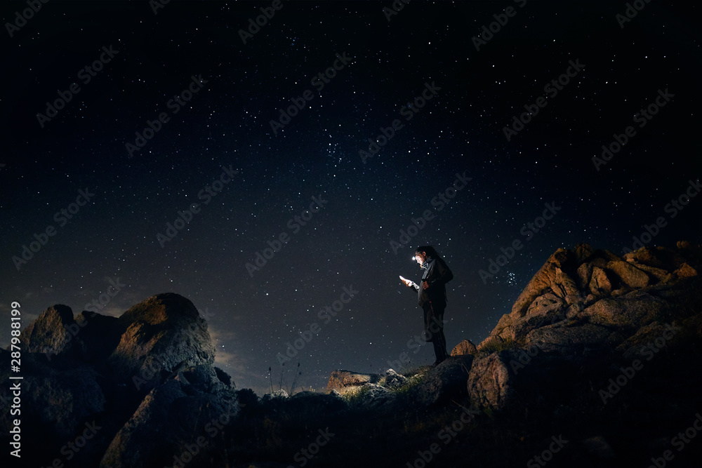 Man in mountains with night sky