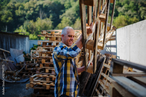 a carpenter repairs wooden pallets © LEREXIS